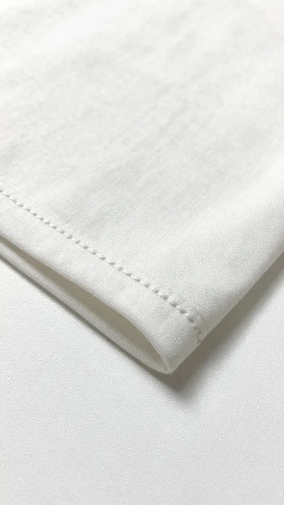Closeup of a neatly hemmed fabric edge with stitching close to fold
